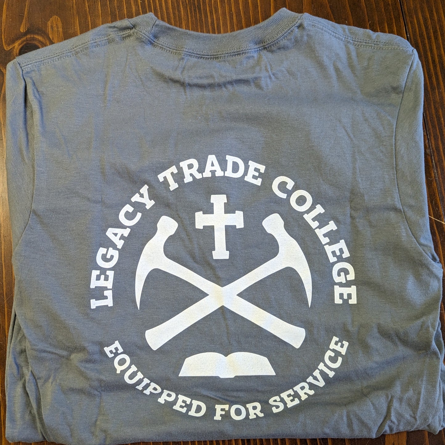 Legacy Trade College Seal with motto, "Equipped for Service" in white.